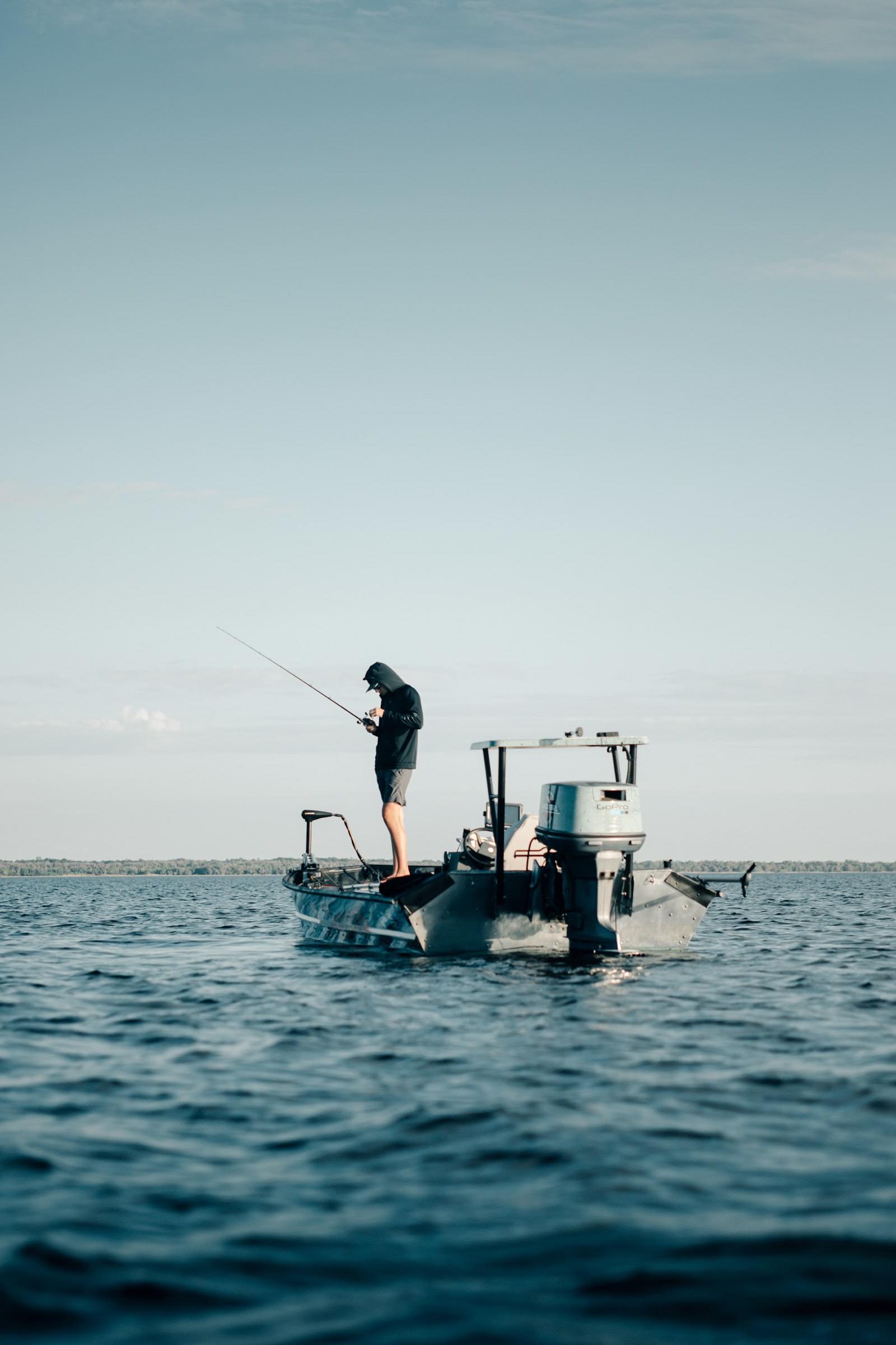 An angler working a rod from a boat on open water